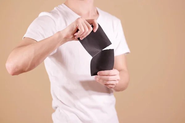 Hombre rasgando un trozo de papel en un folleto de volante negro medio en blanco —  Fotos de Stock
