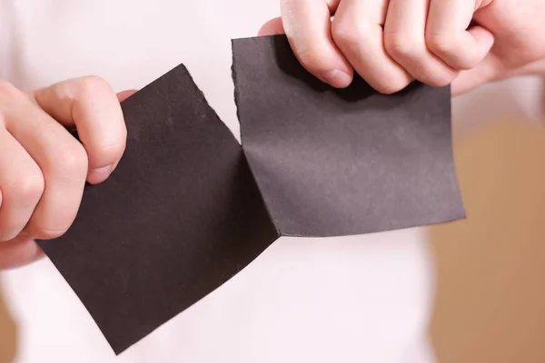 Hombre rasgando un trozo de papel en un folleto de volante negro medio en blanco — Foto de Stock