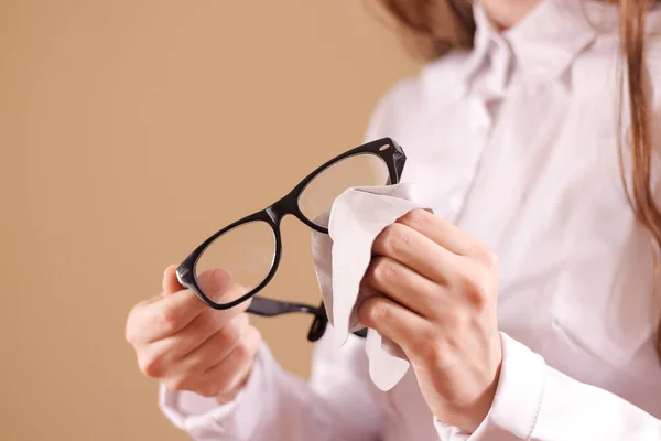 Nők kéz tisztító szemüveg lencse-val elszigetelt háttér — Stock Fotó