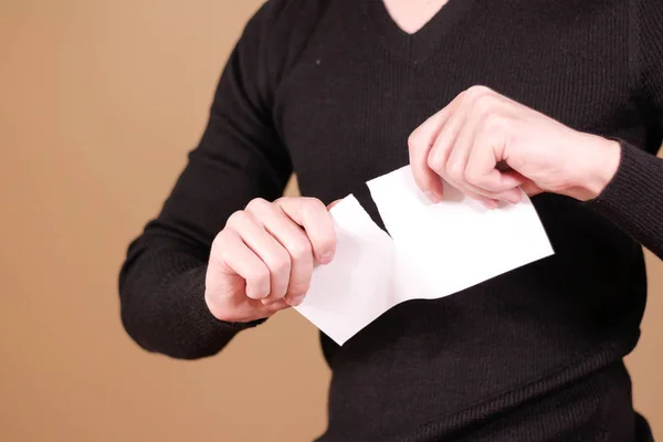 Чоловік розриває шматок паперу навпіл чистий білий флаєр брошури — стокове фото