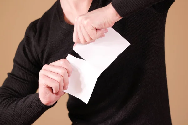 Hombre rasgando un pedazo de papel en un folleto de folleto blanco medio en blanco — Foto de Stock