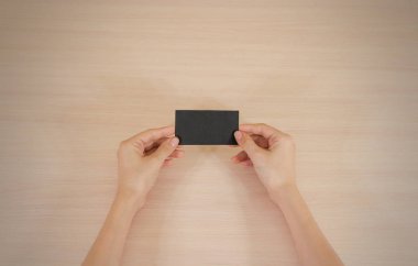 Siyah kartı gösteren eller. Broşür sunumu. Broşür ha tutun