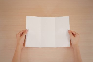Boş beyaz broşür kitapçık elinde tutan eller. Firma broşürü kapak sayfası 