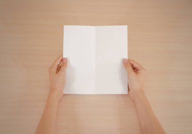 Boş beyaz broşür kitapçık elinde tutan eller. Firma broşürü kapak sayfası 