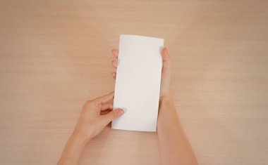 Boş beyaz broşür kitapçık elinde tutan eller. Firma broşürü kapak sayfası 