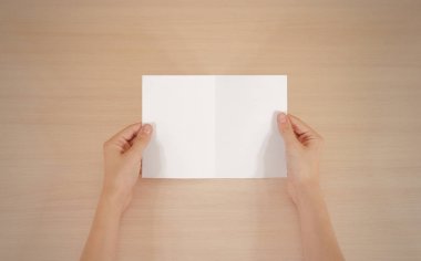 Boş beyaz broşür kitapçık elinde tutan eller. Firma broşürü kapak sayfası 