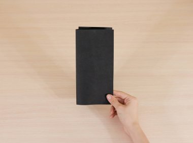 Boş siyah broşür kitapçık elinde tutan eller. Firma broşürü kapak sayfası 