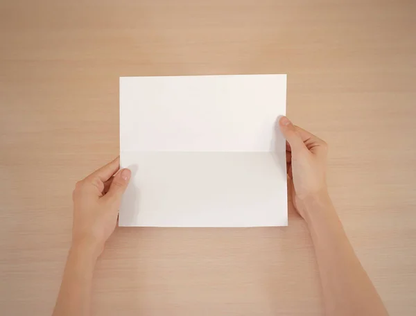Χέρια που κρατούν την κενή λευκή φυλλάδιο βιβλιάριο στο χέρι. Ενημερωτικό φυλλάδιο — Φωτογραφία Αρχείου