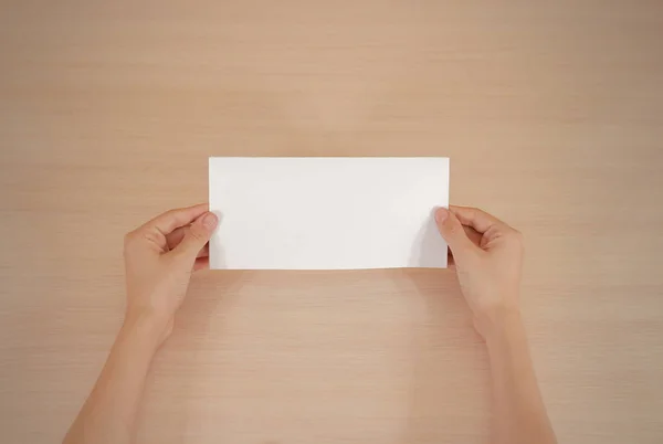 Manos sosteniendo folleto blanco en blanco en la mano. Prospecto — Foto de Stock