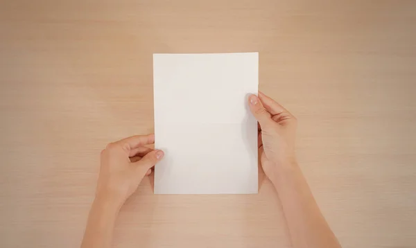 Manos sosteniendo folleto blanco en blanco en la mano. Prospecto — Foto de Stock