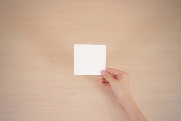 Main droite tenant du papier blanc carré dans la main droite. Brochure — Photo