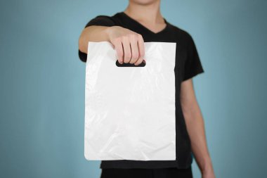 Adam boş plastik torba sahte izole kadar gösterir. Boş beyaz polyet