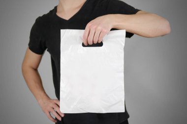 Adam boş plastik torba sahte izole kadar gösterir. Boş beyaz polyet