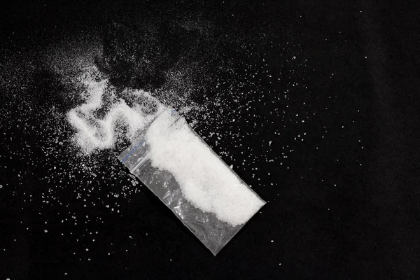 Kokain i väskan, utspridda. Isolerad på en svart bakgrund. — Stockfoto