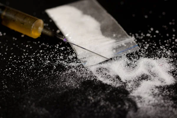 Drug syringe and cooked heroin. Cocaine in the bag, scattered. I — Stock Photo, Image