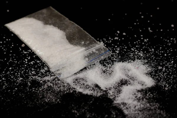 Cocaina nella borsa, sparpagliata. Isolato su uno sfondo nero . — Foto Stock
