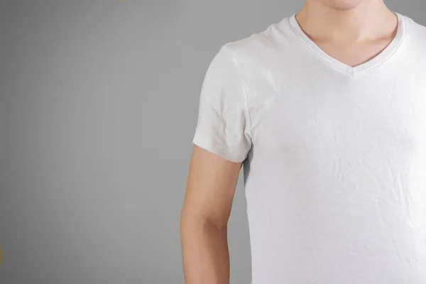 Λευκό πουκάμισο τ σε ένα νεαρό άνδρα πρότυπο σχετικά με γκρι. Απομονωμένα σε γκρι — Φωτογραφία Αρχείου