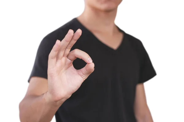 Hombre joven en camiseta negra muestra signo OK. Aislado en la espalda gris —  Fotos de Stock