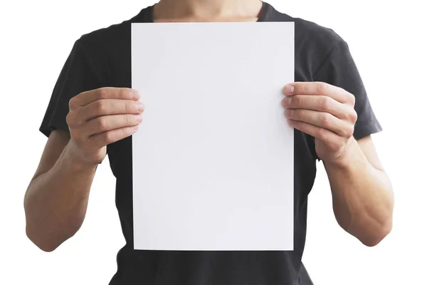 Hombre en camiseta negra sosteniendo en blanco papel A4 verticalmente. Le. —  Fotos de Stock