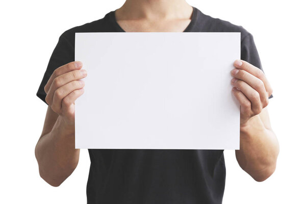 Man in black t shirt holding blank white A4 paper horizontally. 