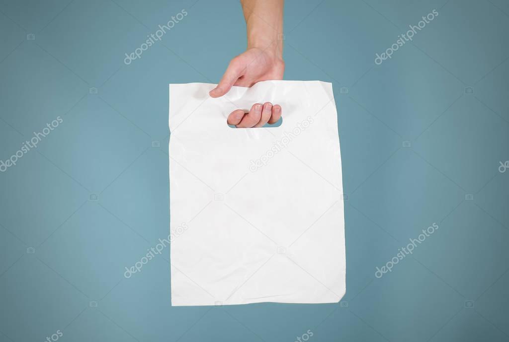 Hand shows blank plastic bag mock up isolated. Empty white polye