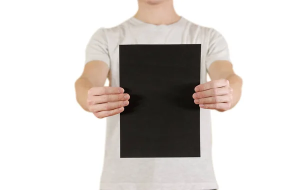 Człowiek posiadający czarnego papieru A4 pionowo. Prezentacji ulotki. Pam — Zdjęcie stockowe