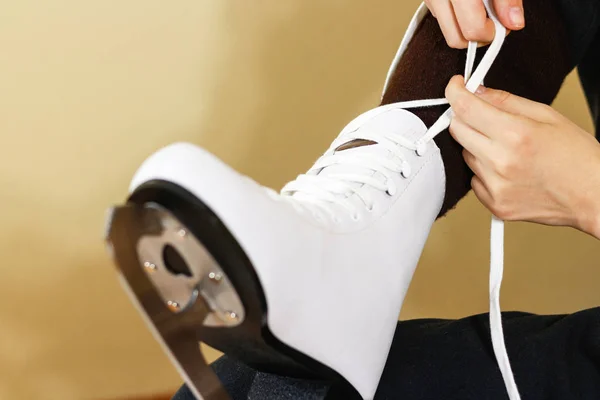 Meisje in jurk wit ijs-of rolschaatsen wanten koppelverkoop schoenveters en voorbereiding — Stockfoto