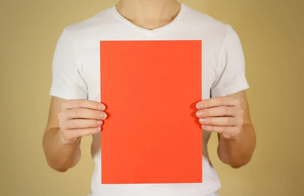 Homem segurando papel A4 vermelho verticalmente. Apresentação do folheto. Pâncreas — Fotografia de Stock