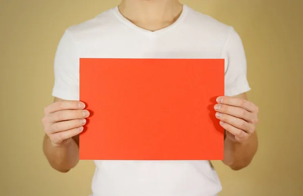 Hombre sosteniendo papel rojo A4 horizontalmente. Presentación del folleto. Pam. — Foto de Stock