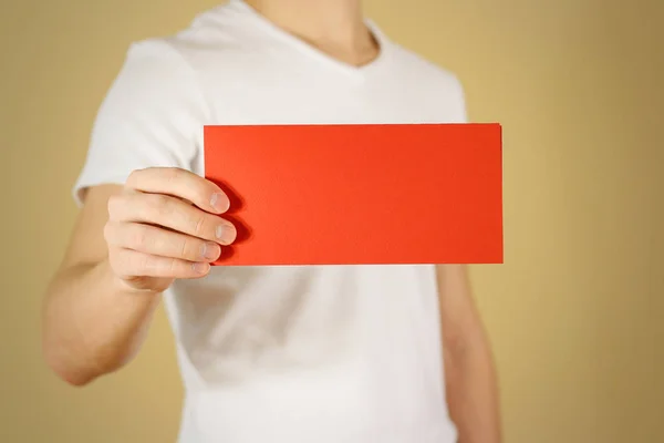 Homem mostrando livreto de folheto vermelho em branco. Apresentação do folheto — Fotografia de Stock