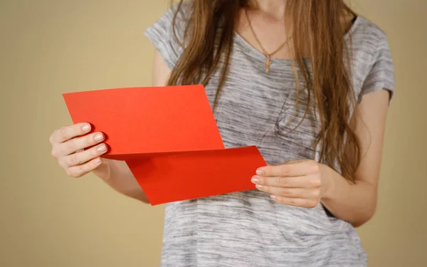 Chica leyendo folleto de folleto rojo en blanco. Lea el folleto detallado. Chica leyendo folleto de folleto rojo en blanco. Lea el folleto detallado. Presentación del folleto. Folleto cogido de la mano. Mujer mostrar papel offset claro. Plantilla hoja. Folleto diseño hoja pantalla leer fi — Foto de Stock