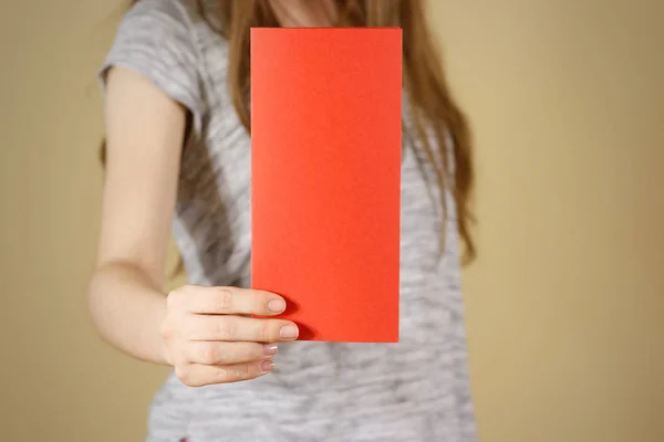Muchacha mostrando folleto volante rojo en blanco folleto. Folleto presentado en — Foto de Stock