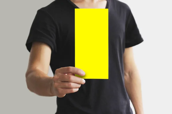 Hombre mostrando folleto de folleto amarillo en blanco. Folleto presente —  Fotos de Stock