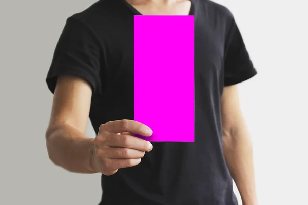 Mann zeigt leeres rosafarbenes Flyer-Broschüre. Faltblatt-Präsentation — Stockfoto