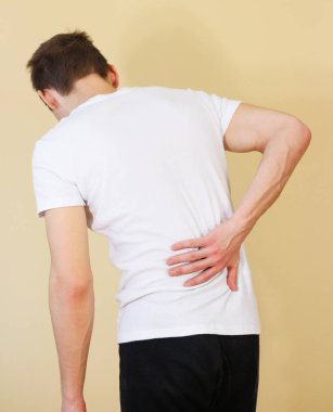 Mutsuz adam beyaz t gömlek sırt ağrısı muzdarip. İzole o