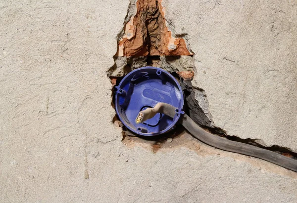 Elektriker demontiert kaputte Steckdose. auf grauem Beton — Stockfoto