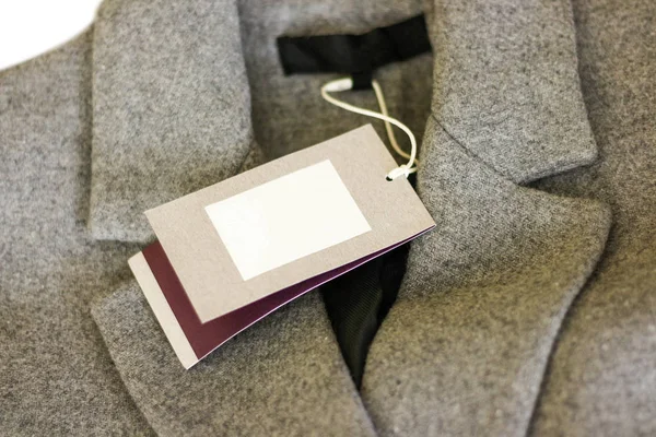 회색 양모 코트의 가격 태그를 닫습니다. 옷, 착용과 패션 — 스톡 사진