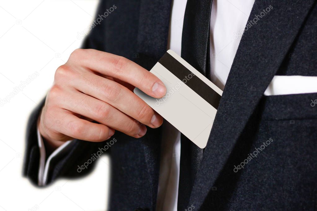 Smartly dressed business man putting a credit card into his pock