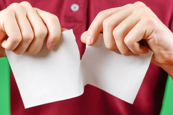 Hombre rasgando un pedazo de papel en un folleto de folleto blanco medio en blanco — Foto de Stock