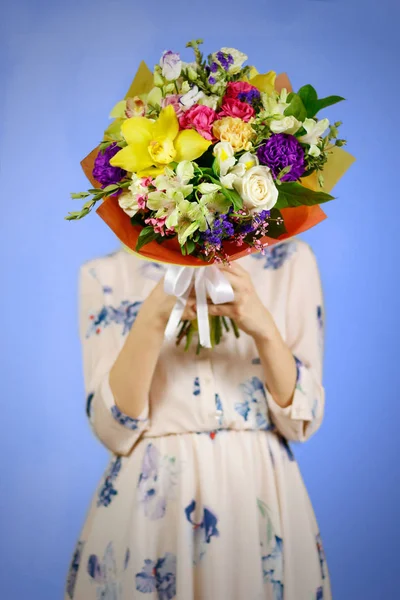 Menina bonita no vestido segurando um buquê de flores diferentes . — Fotografia de Stock