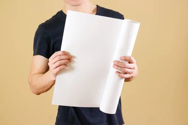 Guy κρατά στα χέρια του συνεστραμμένου επάνω στο χαρτί. Ανοίγει το πακέτο — Φωτογραφία Αρχείου