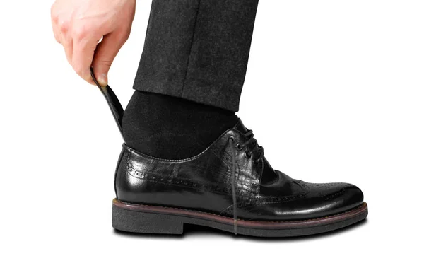 Trägt schwarze Schuhe mit einem Löffel. isoliert auf weißem Hintergrund — Stockfoto