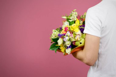 Güzel bir buket çiçek tutan bir Beyaz gömlekli genç adam