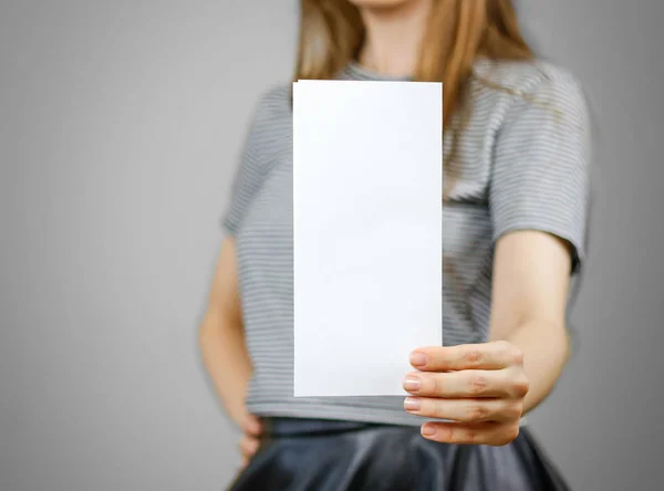 Женщина показывает чистую белую листовку. Презентация брошюры. Пэм — стоковое фото