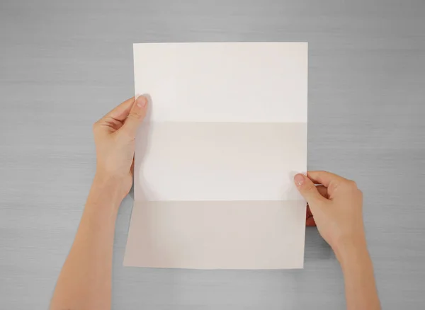 Χέρια που κρατούν την κενή λευκή φυλλάδιο βιβλιάριο στο χέρι. Ενημερωτικό φυλλάδιο — Φωτογραφία Αρχείου