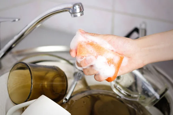 Kadın eli sünger bulaşık için köpük sıkarak — Stok fotoğraf
