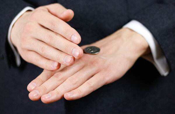 Businessman tossing a coin. Heads or tails. Close up