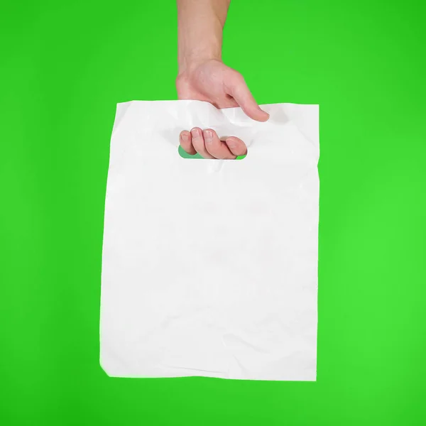 Eli boş plastik torba sahte izole kadar gösterir. Boş beyaz polye — Stok fotoğraf