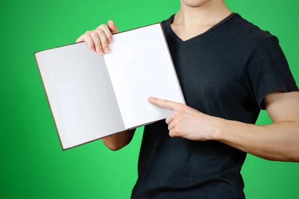 Крупный план парня в черной футболке с пустой белой книгой на — стоковое фото