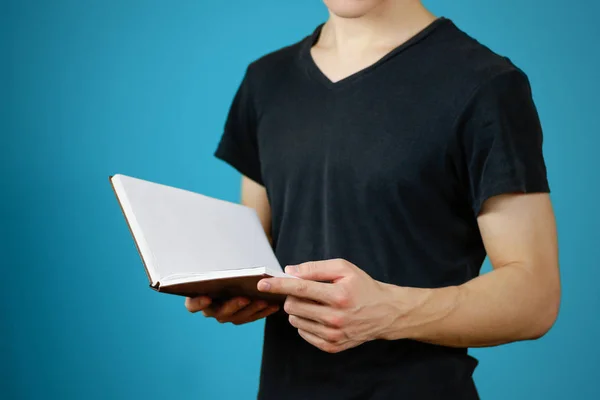 Fechar-se de cara em t-shirt preta segurando em branco livro branco aberto em — Fotografia de Stock